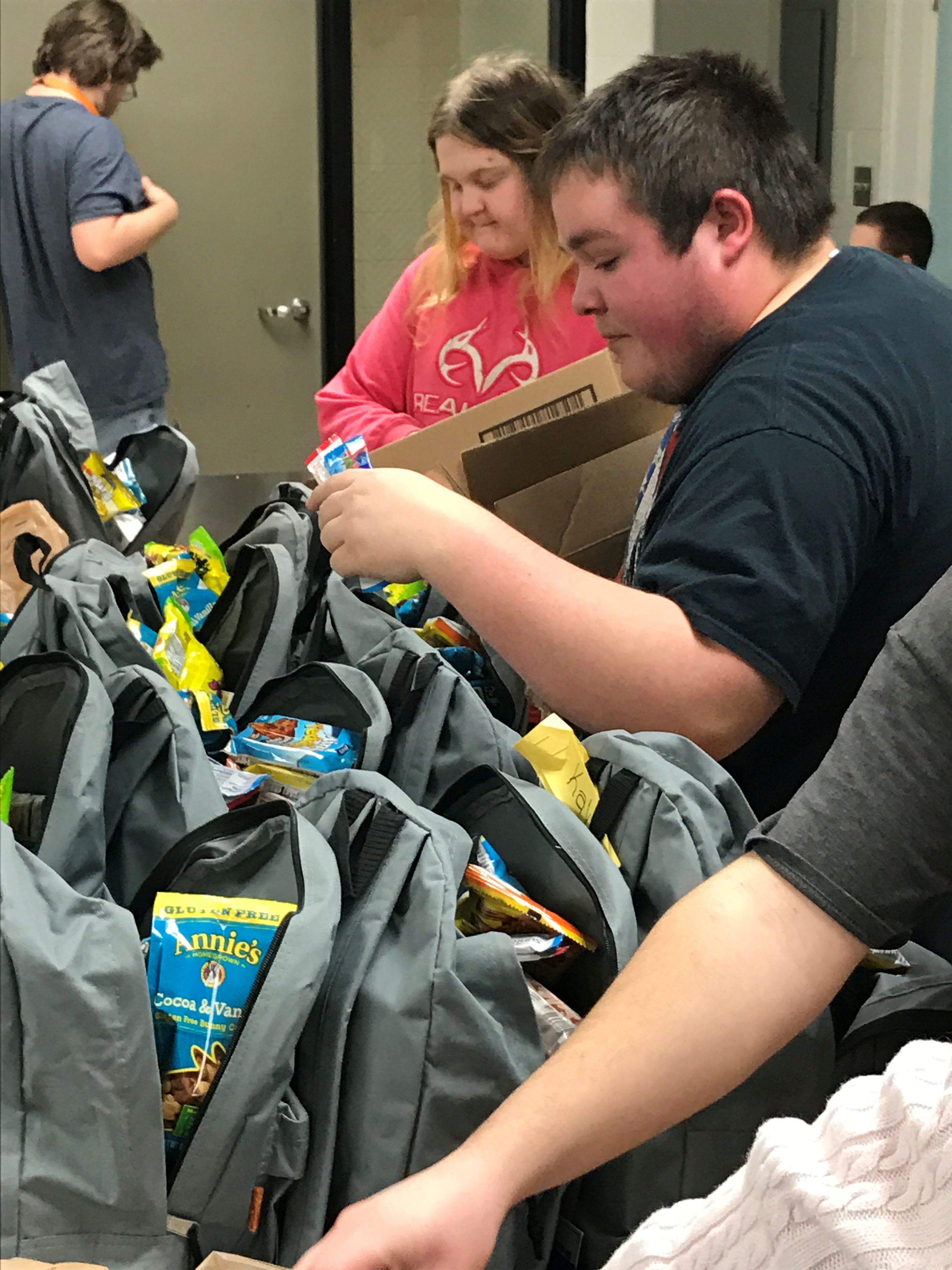 Students packing backpacks of food